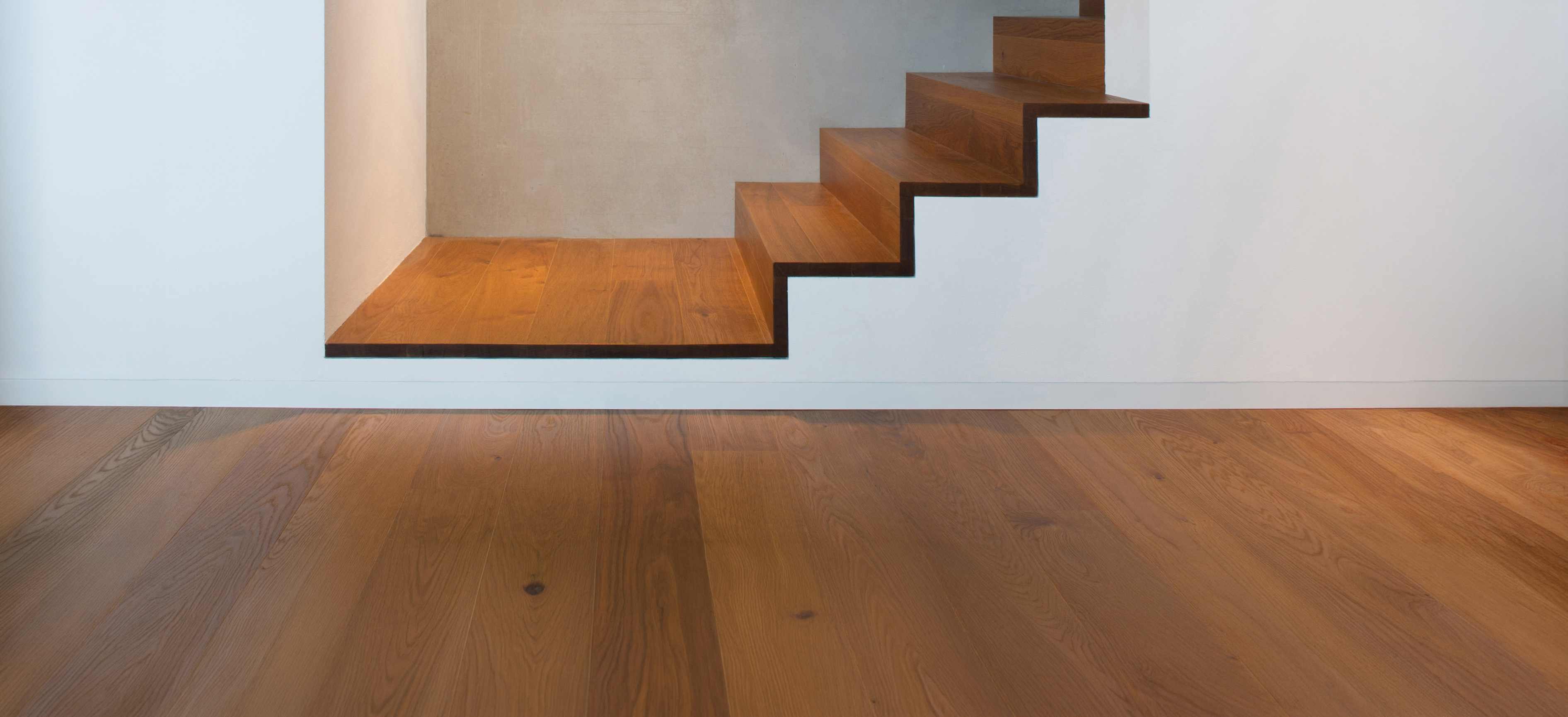 wandbündige Sockelblende und wandbündige Treppe vor Sichtbetonwand