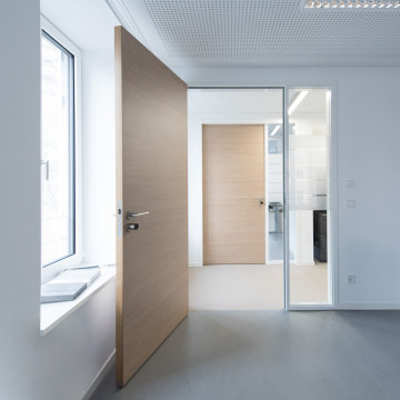 weiße Zarge auf weißer Wand und Holz-Türblatt Türelement in modernem Büro