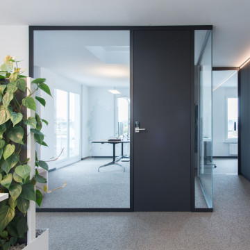 Büro mit großen transparenten Flächen raumhohe Tür mit Eck-Verglasung