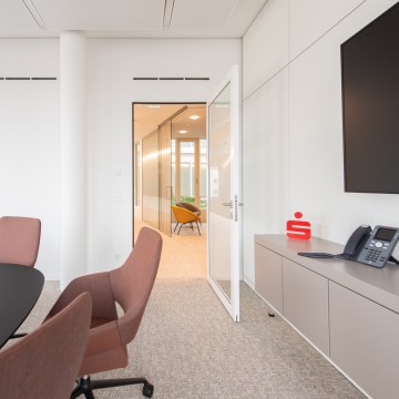 weiße Rahmentür mit Glasfüllung im Konferenzraum, Tisch und Stühle im Vordergrund